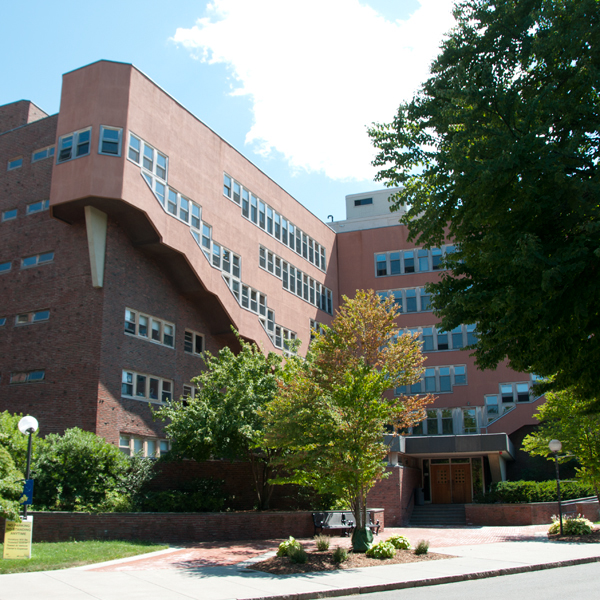 Front entrance of Baker House, with greenery surrounding the front and sides of the building.